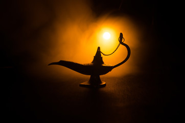 Antique Aladdin arabian nights genie style oil lamp with soft light white smoke, Dark background. Lamp of wishes concept. Toned