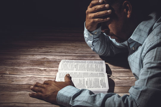 Worried man reading the Holy Bible