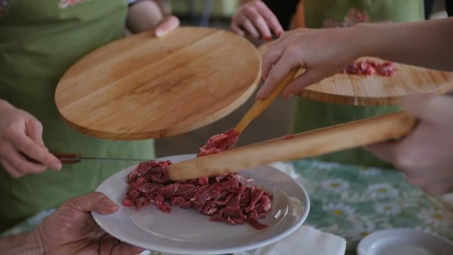 Putting multiple raw meat pieces into the dish