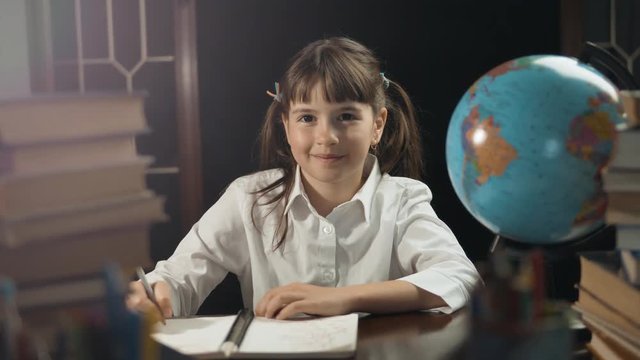 Eight years school girl use globe and notebook, studying place with book, education concept, 30FPS