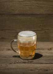 Glass of beer on the wood background