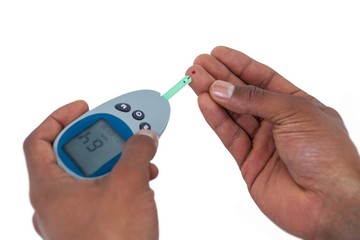 Close-up of man hands testing blood sugar with glucometer 