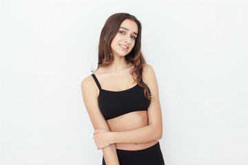 Obraz premium Beautiful girl in black top on white background shows emotion