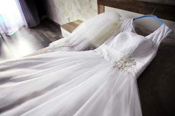 wedding dress lying on bed