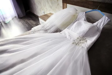Foto op Plexiglas wedding dress lying on bed © Dmitrijs Mihejevs