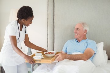 Obraz premium Nurse serving breakfast to senior patient