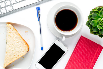 coffee break with sandwich, mobile, keyboard on woman office desk background top view