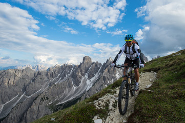 Fototapeta premium biker rides alone in the dolomite mountains