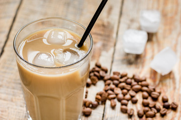 Ice coffee with milk and beans for lunch on wooden background