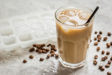 coffee break with cold iced latte and beans on stone table background