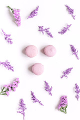 macaroons and flowers for light breakfast on white desk background top view pattern