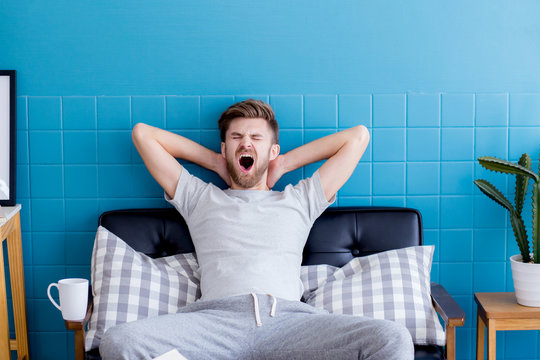 man yawning and going asleep in his  living room