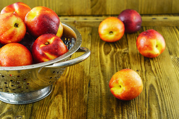 Plenty mellow orange red nectarines on rough rustic wooden background selective focus.