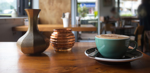 Hot cappuccino on a table inside a coffee shop.