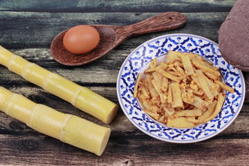 Fried soft bamboo pole shoots with egg and kitchen equipment cooking.