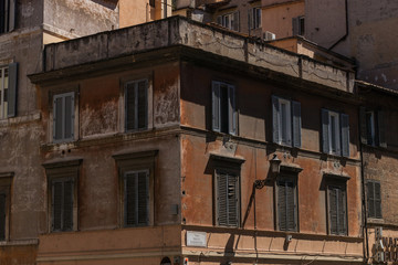 Fototapeta na wymiar fragment starego włoskiego domu z zamkniętymi okiennicami w pełnym słońcu
