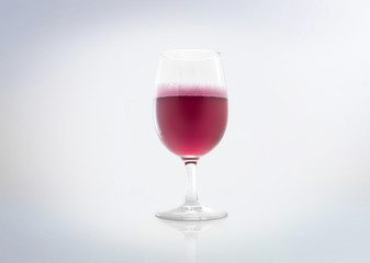 Glass of a red drink with bubbles (rosé champagnes & sparkling strawberry / cherry). Isolated on white background.