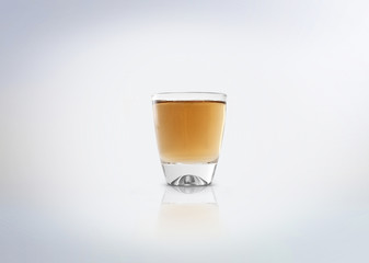 Gold shot of tequila, rum, schnapps, akvavit, pisco, cachaca or other alcoholic distilled beverage. Isolated on white background.