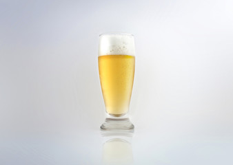 Glass of light lager beer with foam. Isolated on white background.