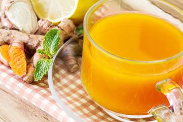a cup of Turmeric Tea with lemon and ginger , Benefits for reduce Inflammation , Liver Detox and Cleanser healthy herb drink concept