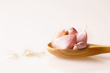 Close up garlic in a wooden spoon on white background