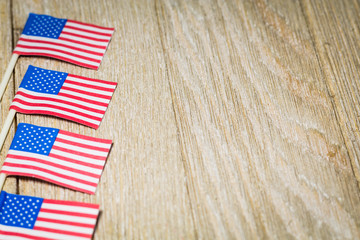 Fototapeta premium Miniature flags on left side of wooden board with room for copy