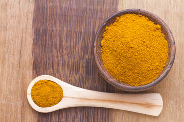 turmeric powder on wood background (curcuma longa)