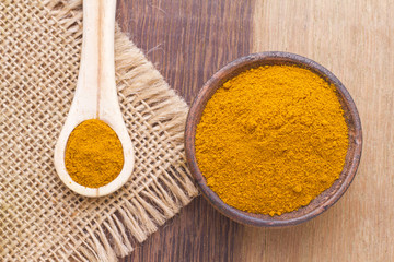 turmeric powder on wood background (curcuma longa)
