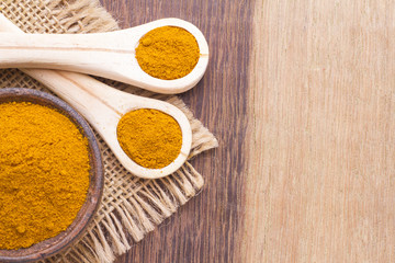 turmeric powder on wood background (curcuma longa)