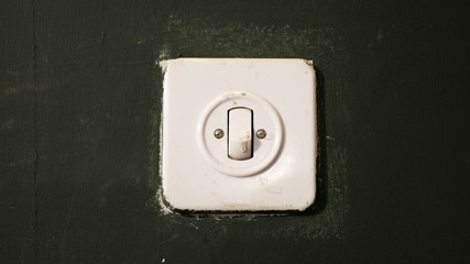 Toggle ON OFF light switch on green wall