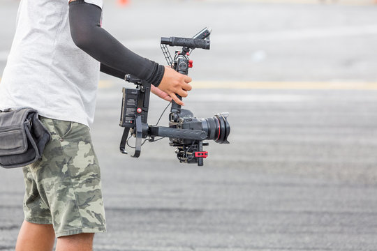 Videographer takes video camera with gimball video dslr, free copy space for your text
