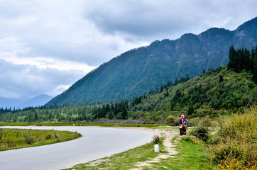 Fototapeta na wymiar A hiker in the road to jiuzhai valley,China