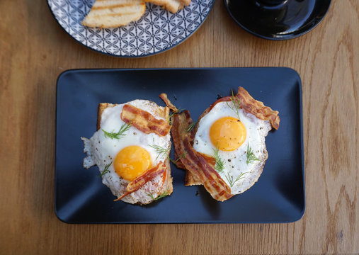 fried eggs with crispy bacon on toast