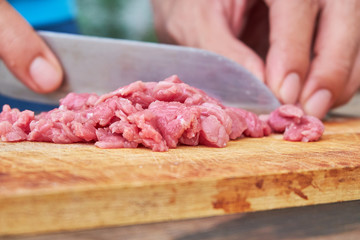 Butcher cutting pork meat on kitchen
