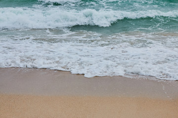 Soft wave of blue ocean on sandy beach. Background.