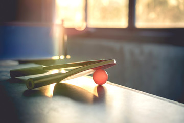One pair of table tennis and table tennis Stay on the table and have netting as the background. By the evening sun after workout after work for good health.