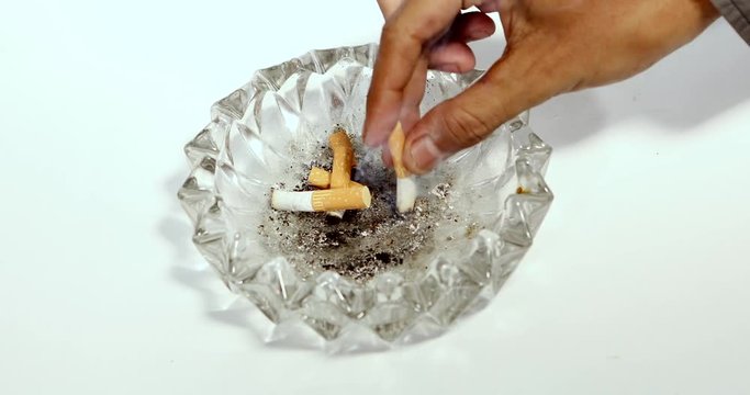 Video footage of a male hand putting out cigarette butts on the ashtray. Stop smoking concept. Shot in 4k resolution