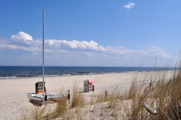 Obraz premium Katamaran und einzelner, rot-weiß gestreifter Strandkorb, Strand in Heringsdorf, Usedom, MV