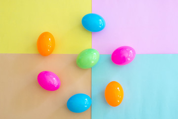 colorful toy eggs on colorful background. top view.