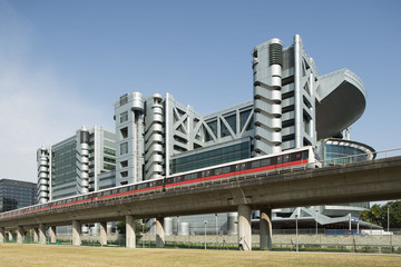 An SMRT Train driving past the headquarters of Singpost.
