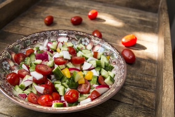bowl with vegetable spring cut salad, tomato, pepper, radish, cucumber