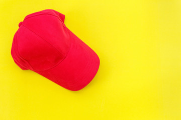 New blank red baseball hat on yellow background with free space for design