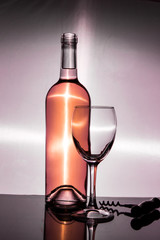 A bottle of white wine is an empty glass and a corkscrew