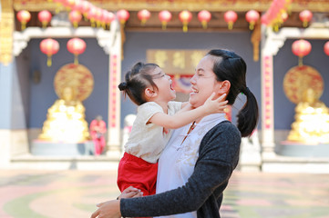 portrait of mother and cute little girl in Yaowarat Road (Bangkok chinatown) at Chinese new year, Bangkok Thailand.