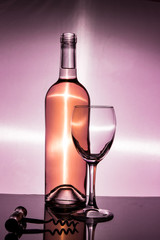A bottle of white wine is an empty glass and a corkscrew