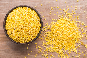 Peeled mung beans in wooden bowl put on wooden plank background
