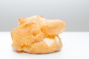 Profiteroles stuffed with pastry cream on white desk in cafe