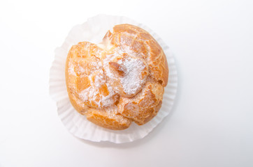 Profiteroles stuffed with pastry cream on white desk in cafe
