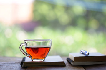 Tea in glass and notebooks with pen at window