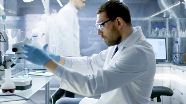 In a Chemical Research Laboratory Scientist Mixes Smoking Compounds in Beakers. Shot on RED EPIC-W 8K Helium Cinema Camera.